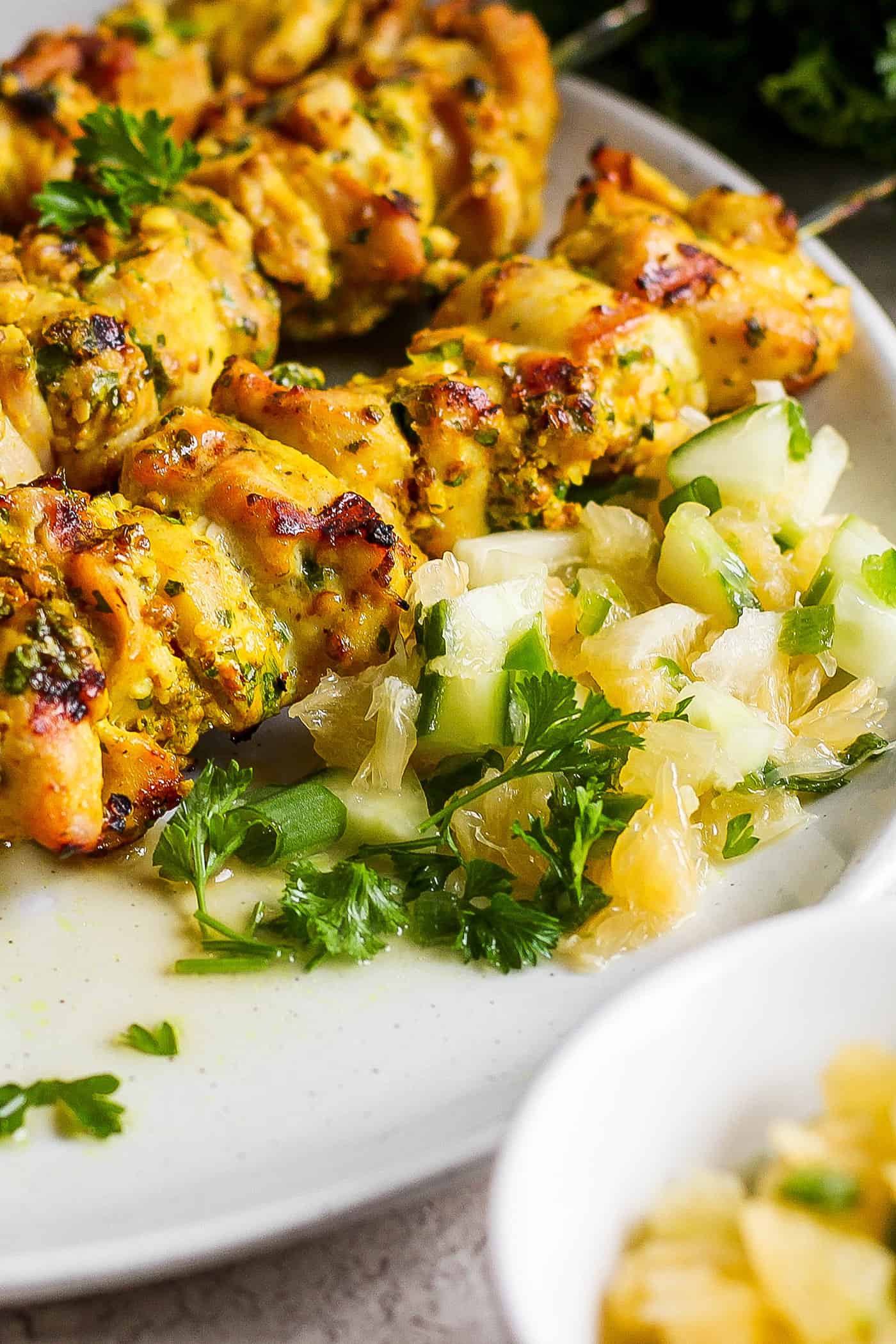 Chicken kabobs are shown with a portion of Meyer lemon salsa next to them.