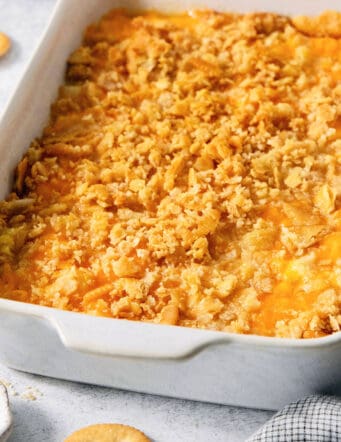 A white baking dish holds cracker-topped pineapple casserole.