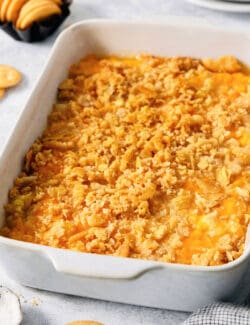 A white baking dish holds cracker-topped pineapple casserole.