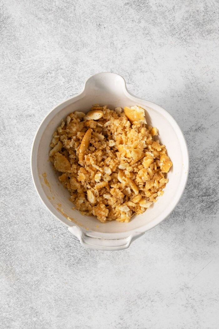 Crushed ritz crackers in a white bowl.