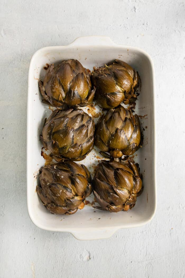 The artichokes in the baking dish after being roasted.