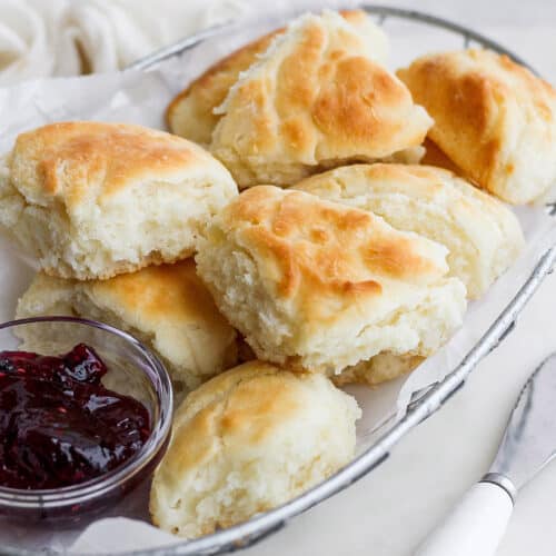 Touch of grace biscuits in a wire basket with a dish of jam.