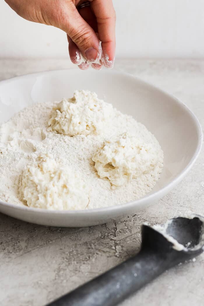 Biscuit dough is rolled in flour.