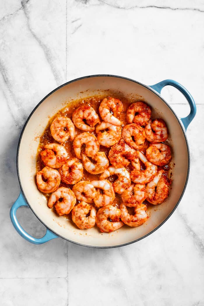 Shrimp cooks in a pot for cajun shrimp pasta.