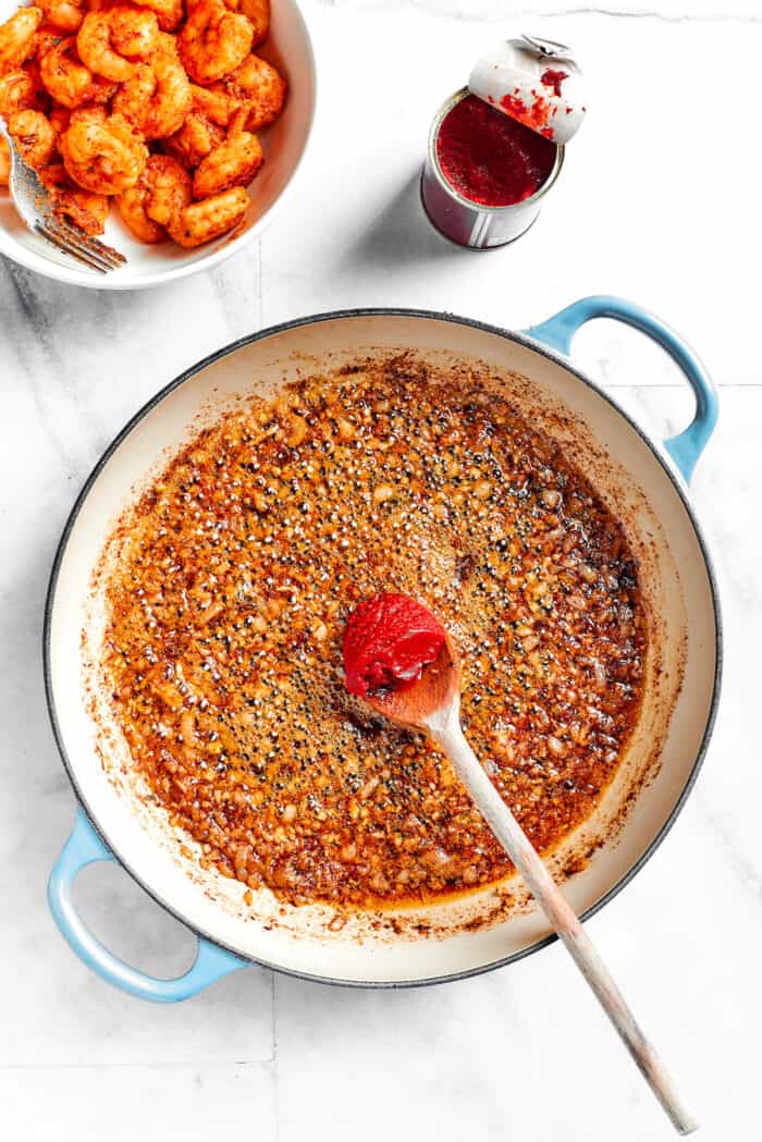 Tomato paste is stirred into the seasonings.