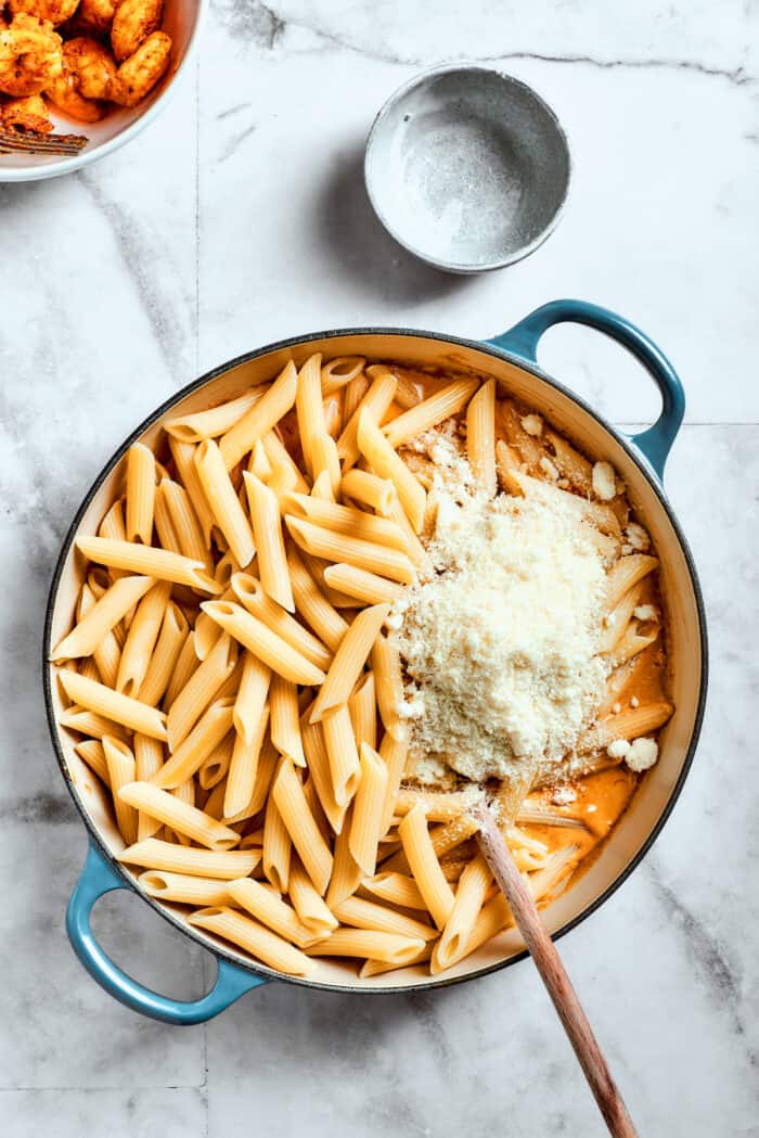 Cheese is added to the pasta.