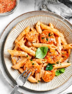 A plated bowl of cajun shrimp pasta with a fork resting on the side.