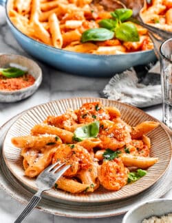 A fork rests on a bowl of cajun shrimp pasta.