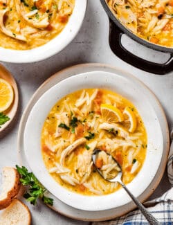 overhead photo of bowls and a pot of chicken soup with lemon and orzo