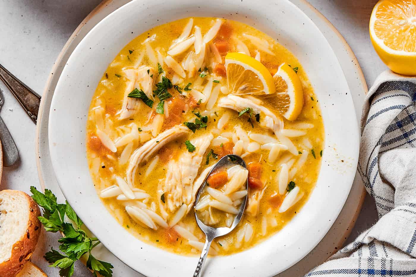 a bowl of chicken soup with lemon and orzo