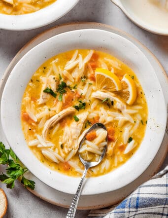 overhead photo of a white bowl with lemon chicken orzo soup