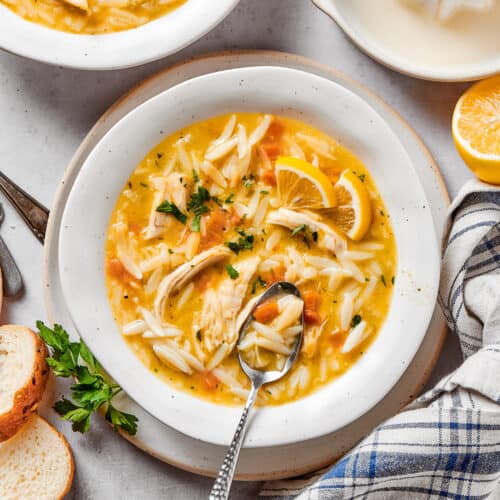 overhead photo of a white bowl with lemon chicken orzo soup