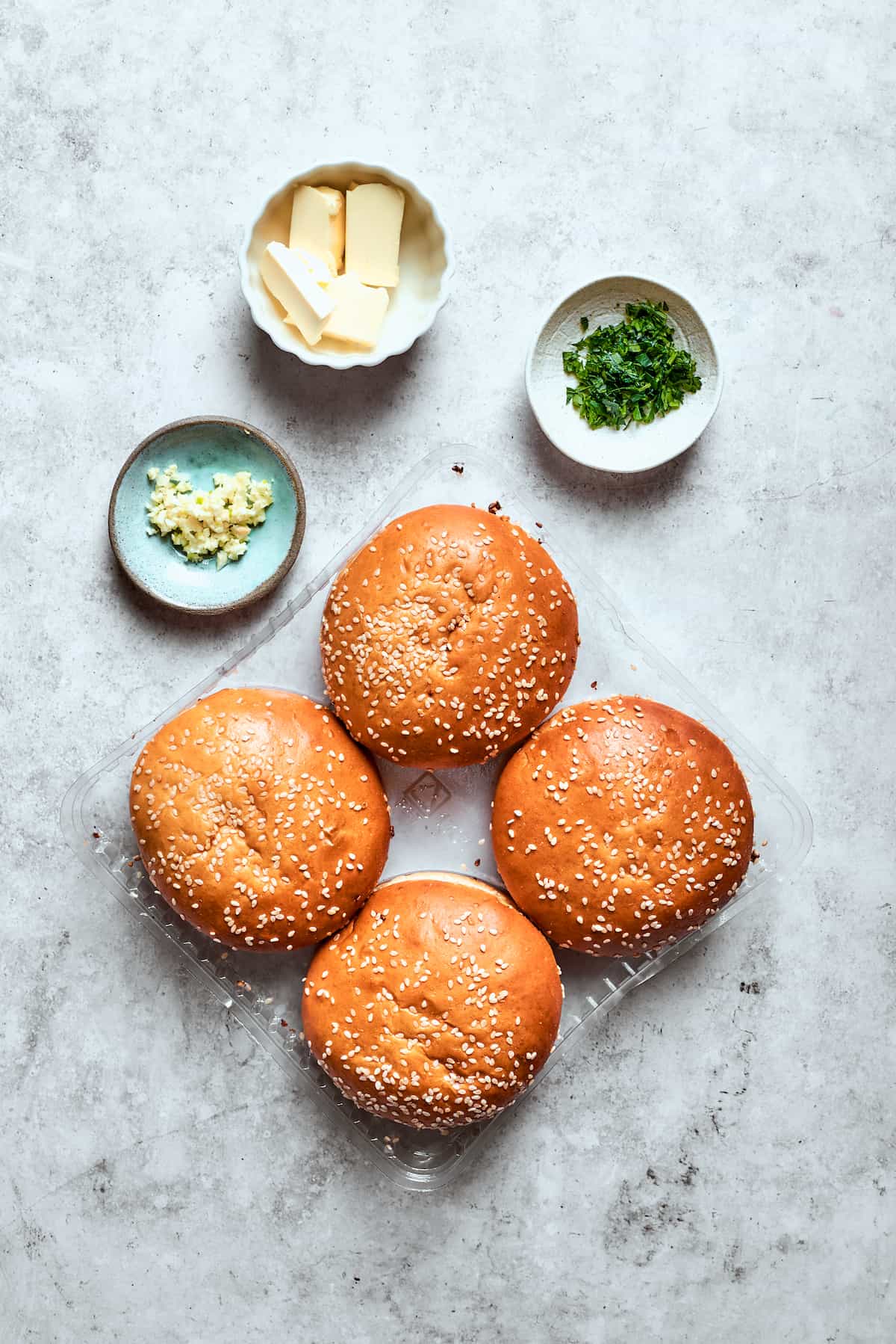 Blend two favorites to make this Pizza Burger recipe! Juicy beef patties are topped with tangy marinara, pepperoni, mozzarella & fresh basil. The pizza burger buns ingredients are shown: buns, garlic, herbs, butter.
