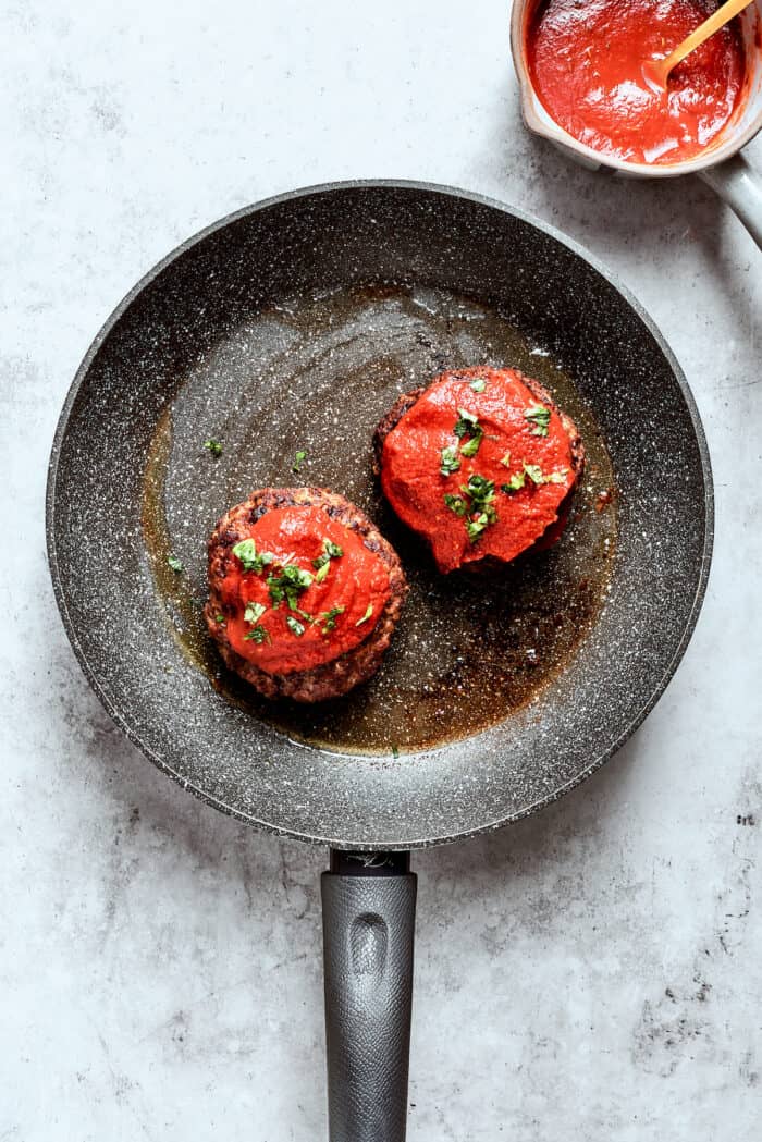 Blend two favorites to make this Pizza Burger recipe! Juicy beef patties are topped with tangy marinara, pepperoni, mozzarella & fresh basil. Herbs are scattered atop the burgers.