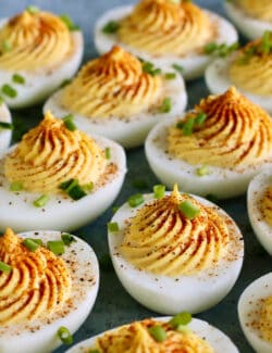 deviled eggs garnished with paprika and chives