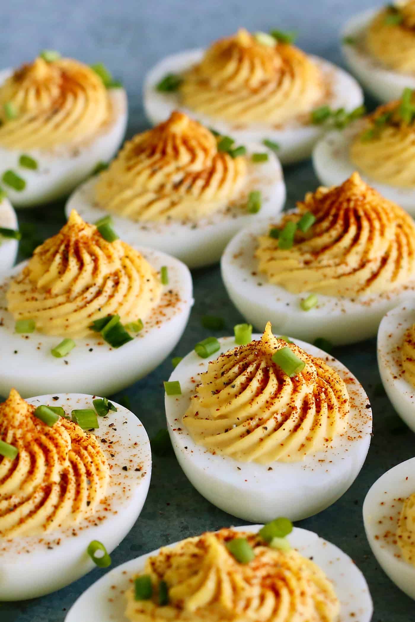 deviled eggs garnished with paprika and chives