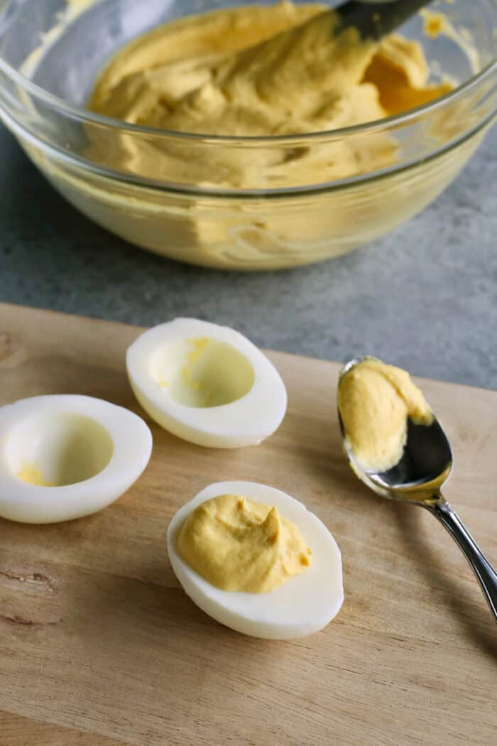 Adding the filling to the egg whites with a spoon.