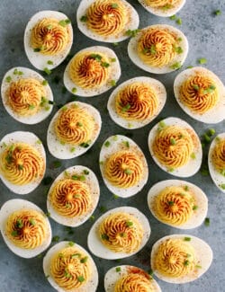 overhead photo of classic deviled eggs garnished with paprika and chives