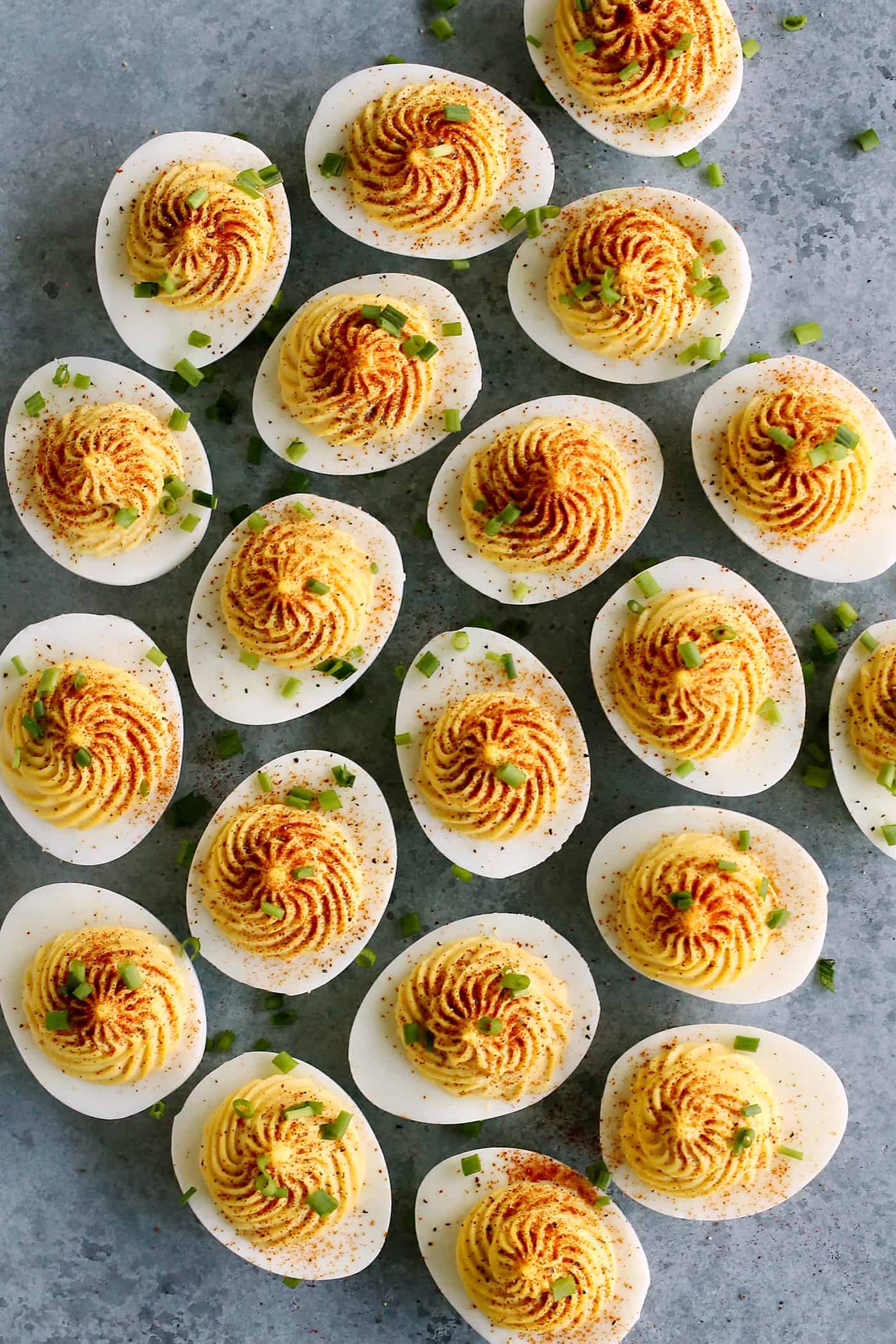 overhead photo of classic deviled eggs garnished with paprika and chives