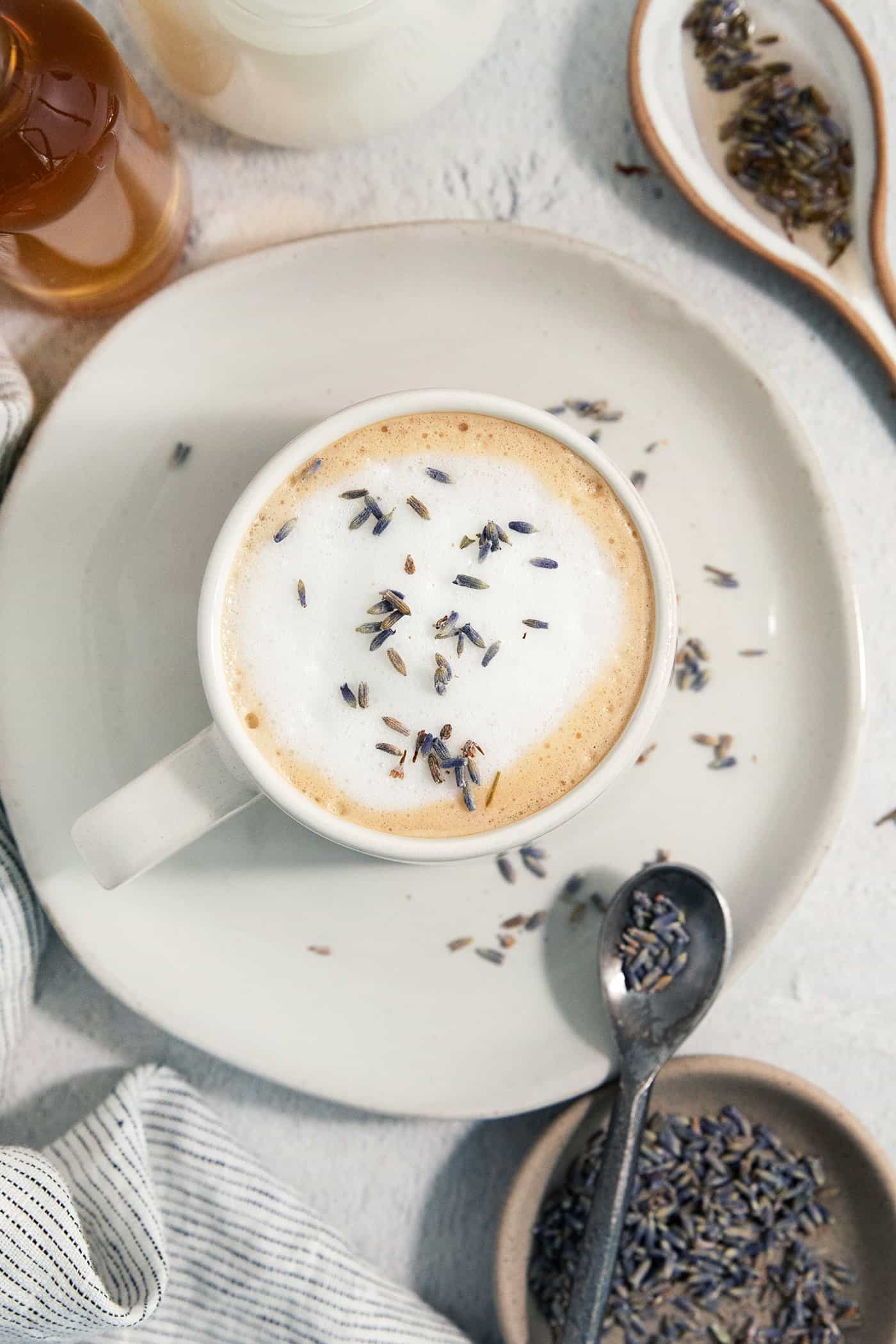 Lavender tops a creamy lavender latte on a plate.