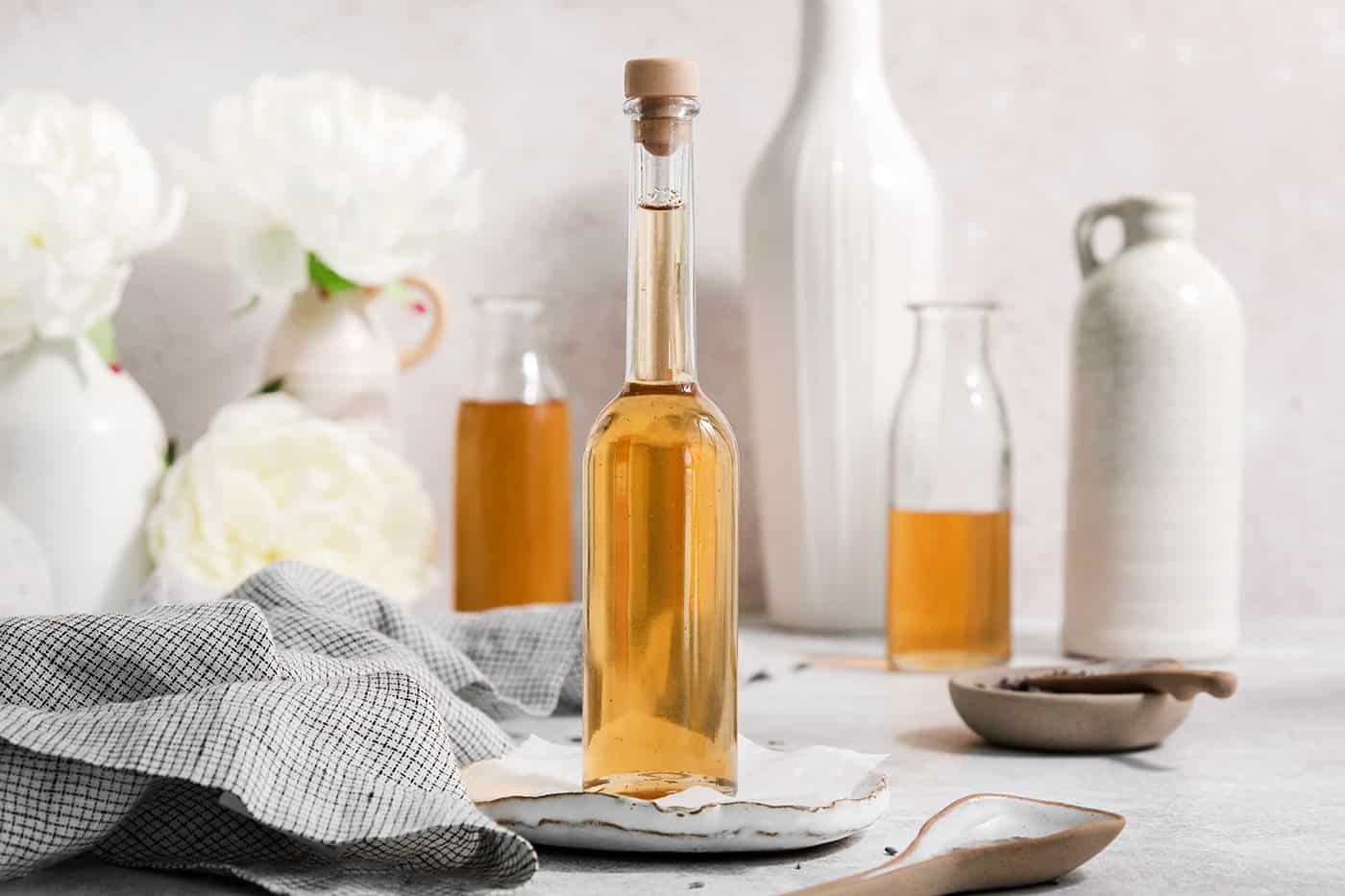 A glass bottle full of lavender simple syrup that's stopped with a cork.