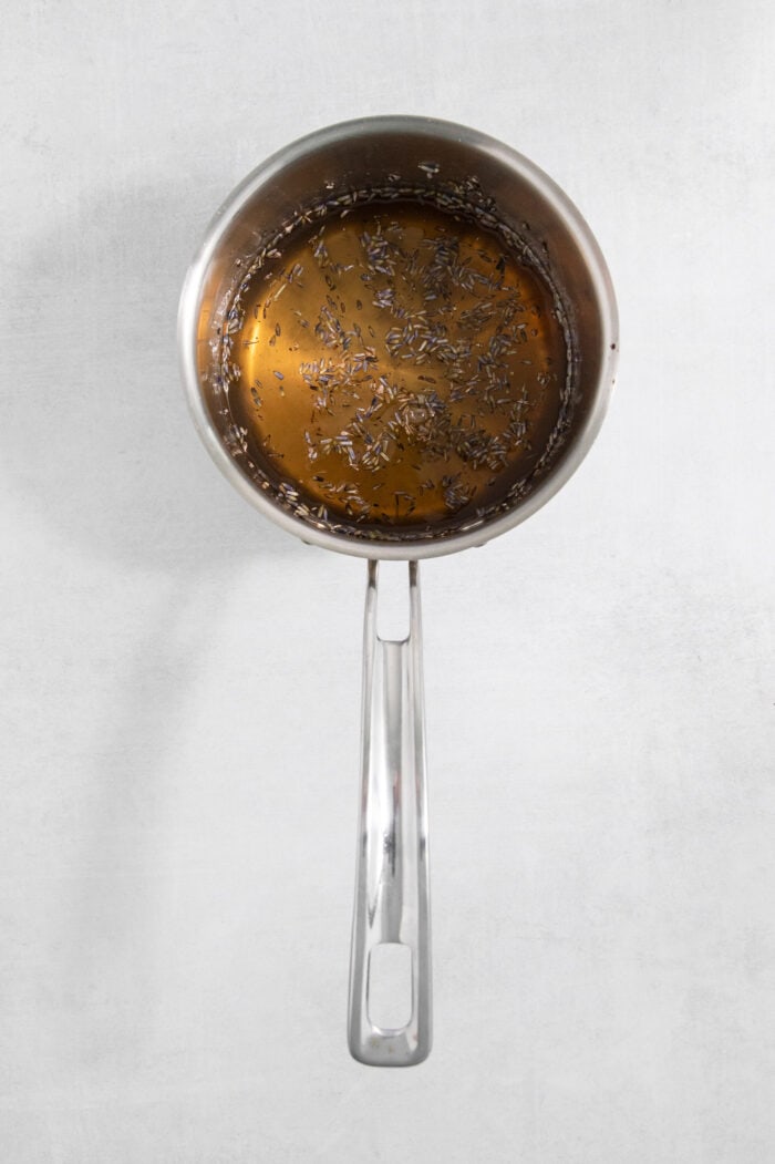 A saucepan holds the ingredients for lavender simple syrup as they cook.