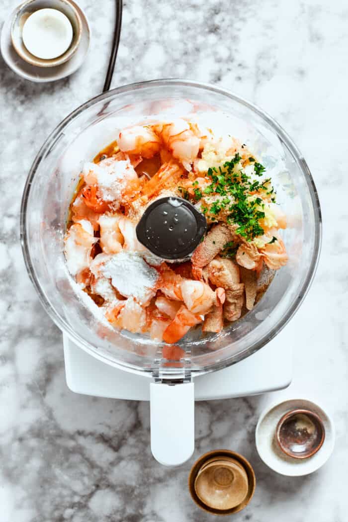 A food processor holds the filling ingredients for shrimp shumai.