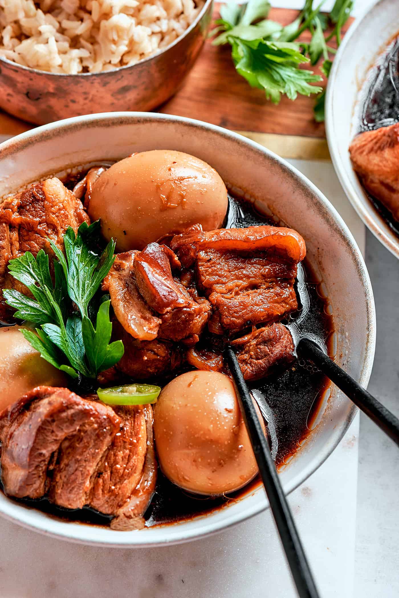 thit kho in a bowl with chopsticks