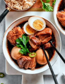 overhead photo of thit kho in a bowl with chopsticks, with one hardboiled egg cut in half