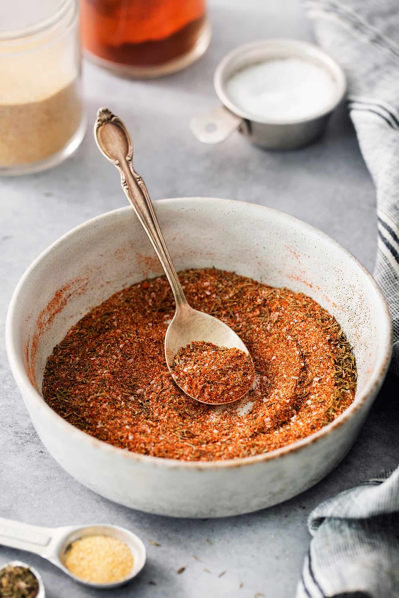 dried spices and herbs in a bowl, with a spoon