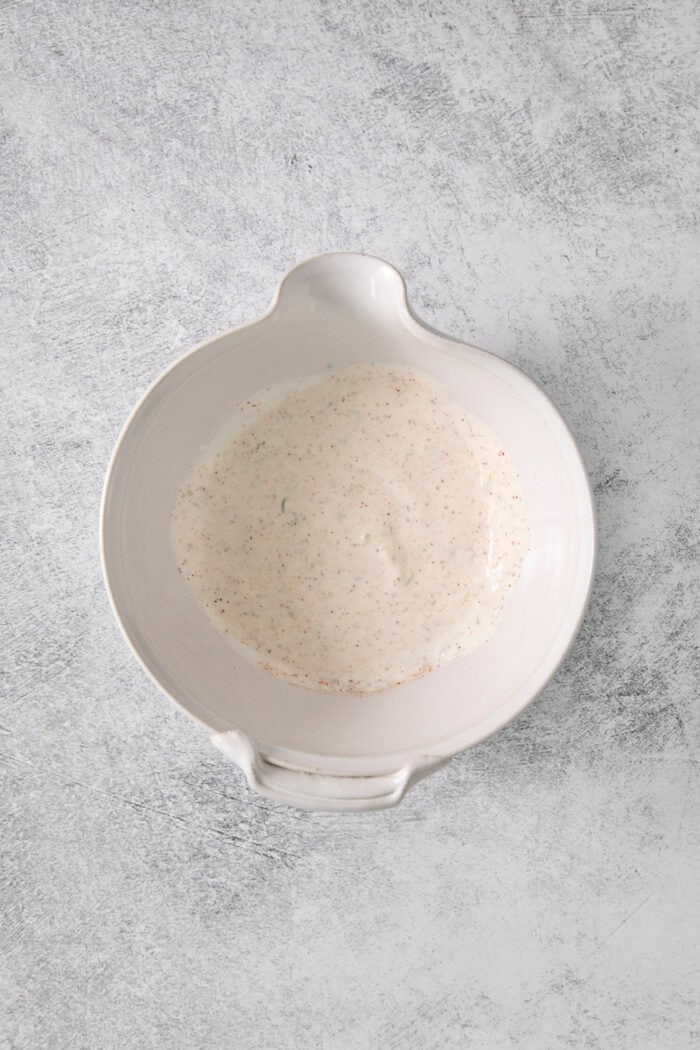 The avocado crema in a white bowl.