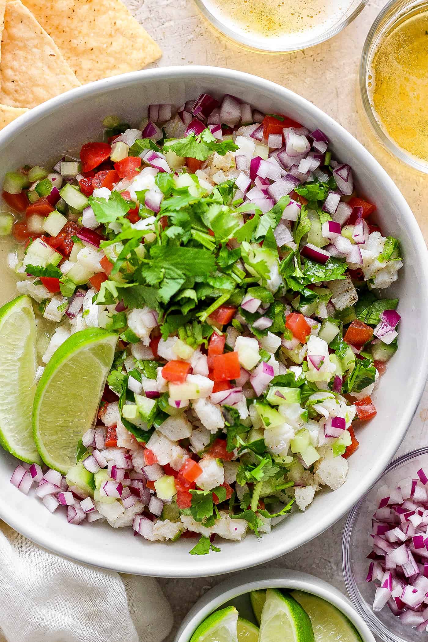 A bowl of classic ceviche with lime wedges.