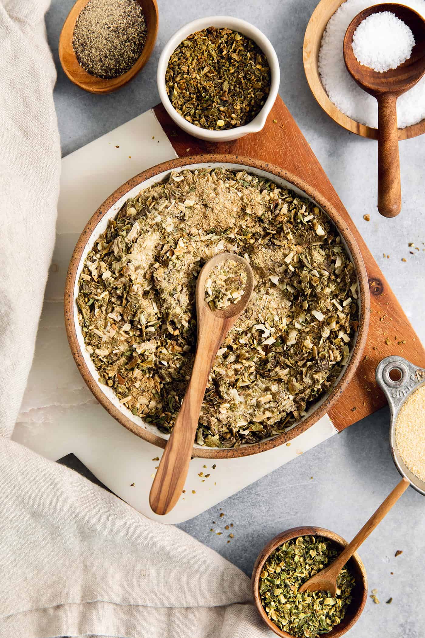 A big bowl of green taco seasoning with a wooden spoon resting in it.