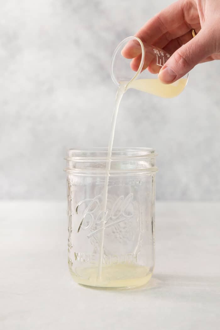 Lime juice is added to a jar to make a classic margarita.