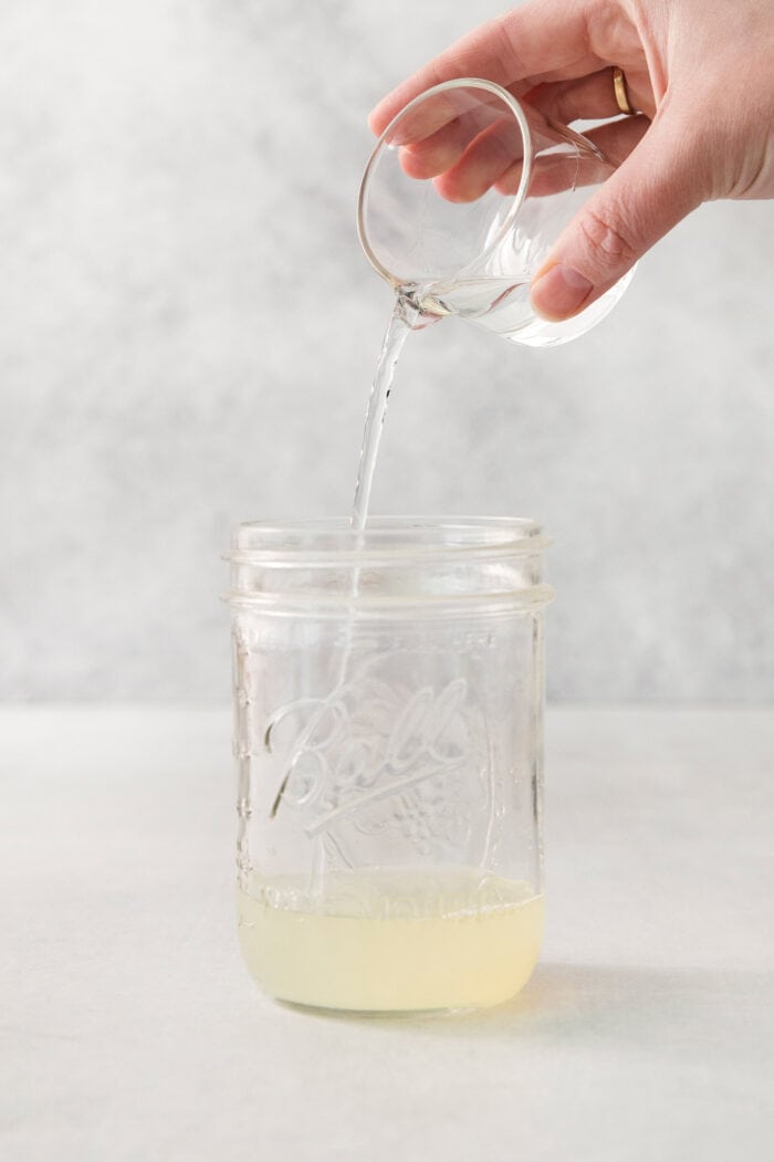 Orange liqueur is poured into the jar.