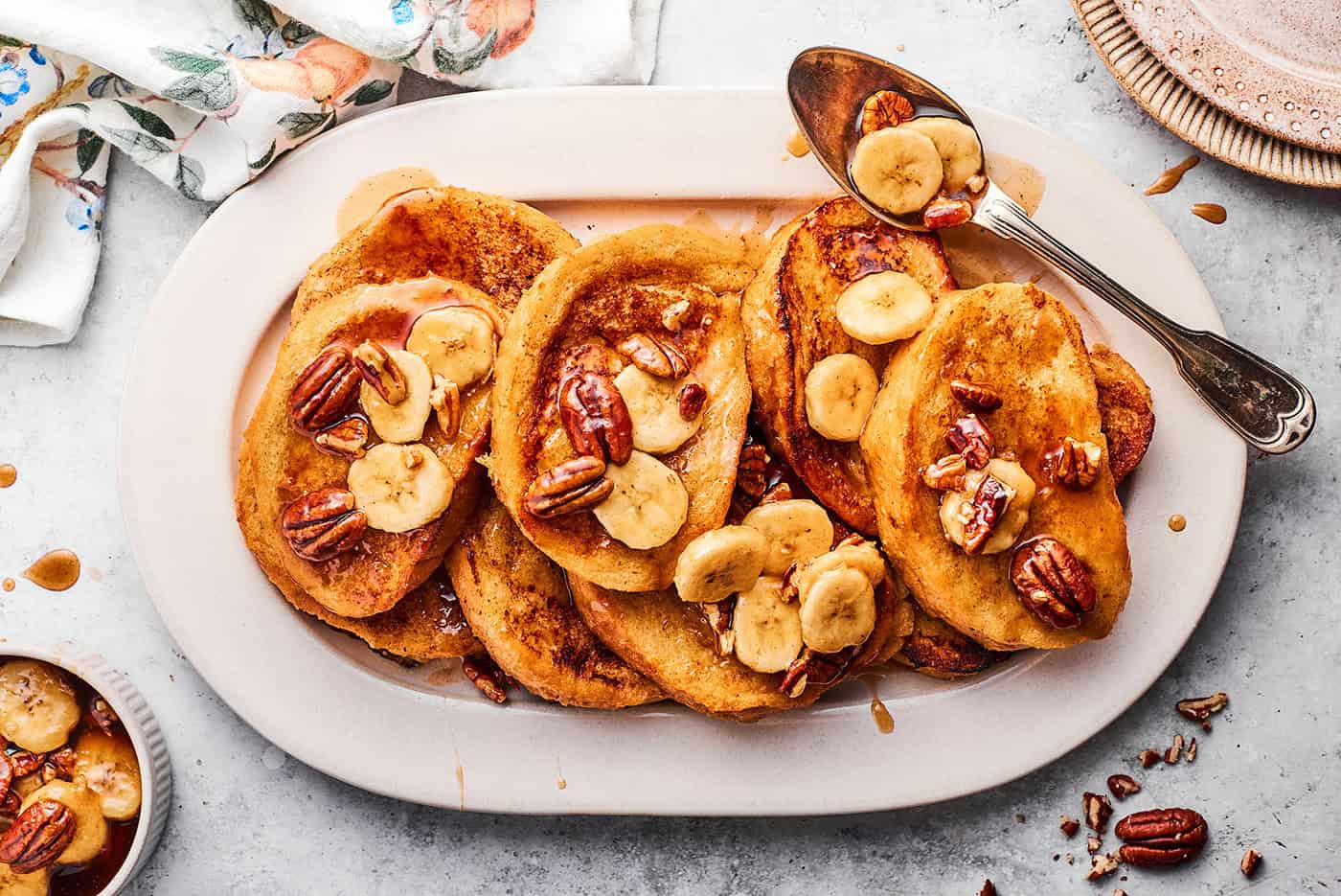 French toast with bananas foster sauce, layered on a white platter