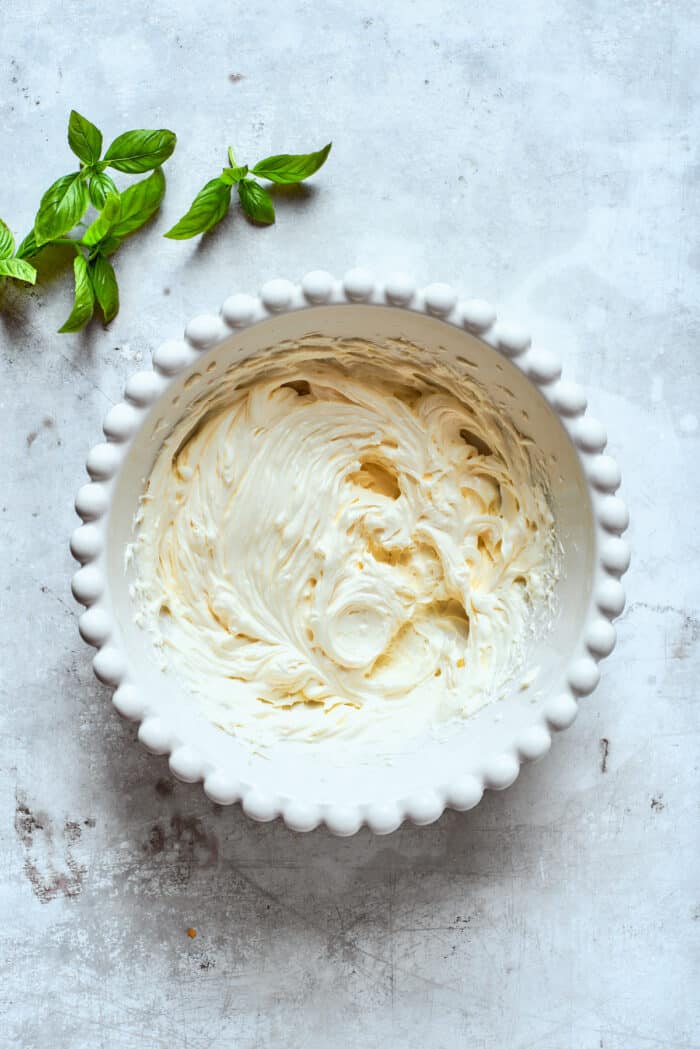 Cream cheese is added to a baking dish.