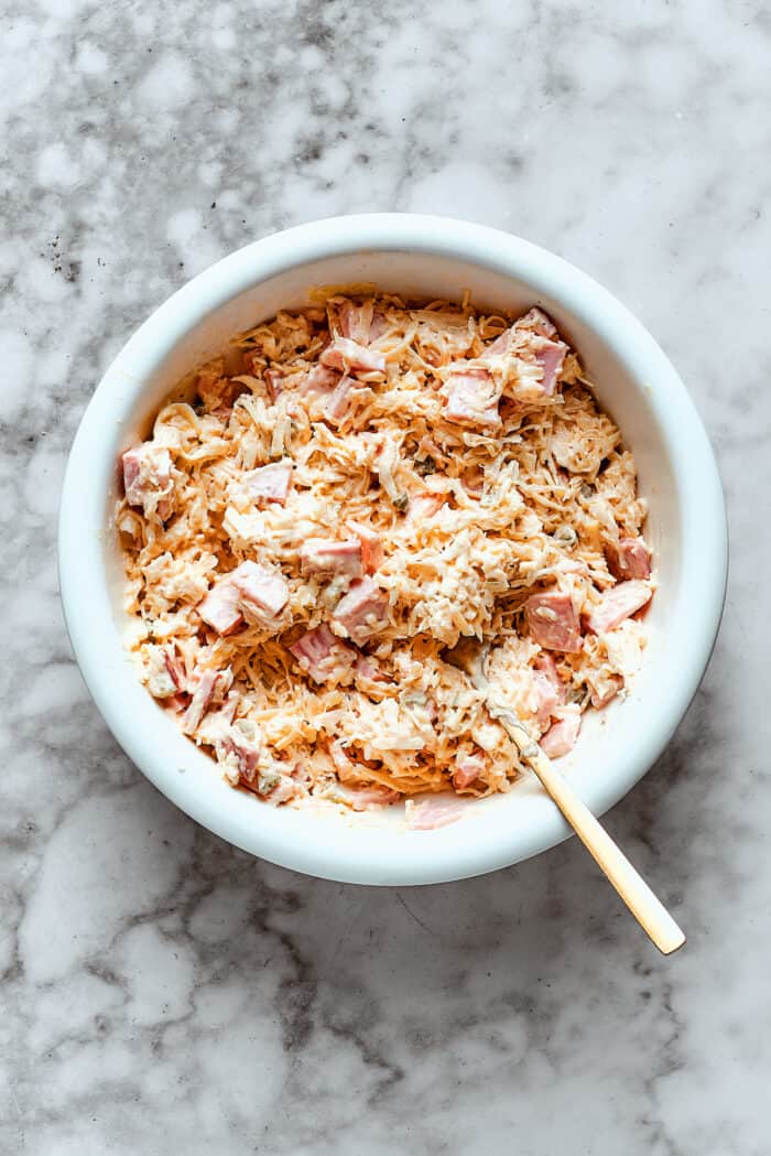 Stirring together Reuben dip ingredients in bowl
