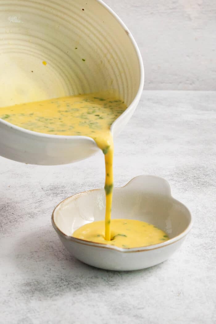The egg mixture is poured into a ramekin.
