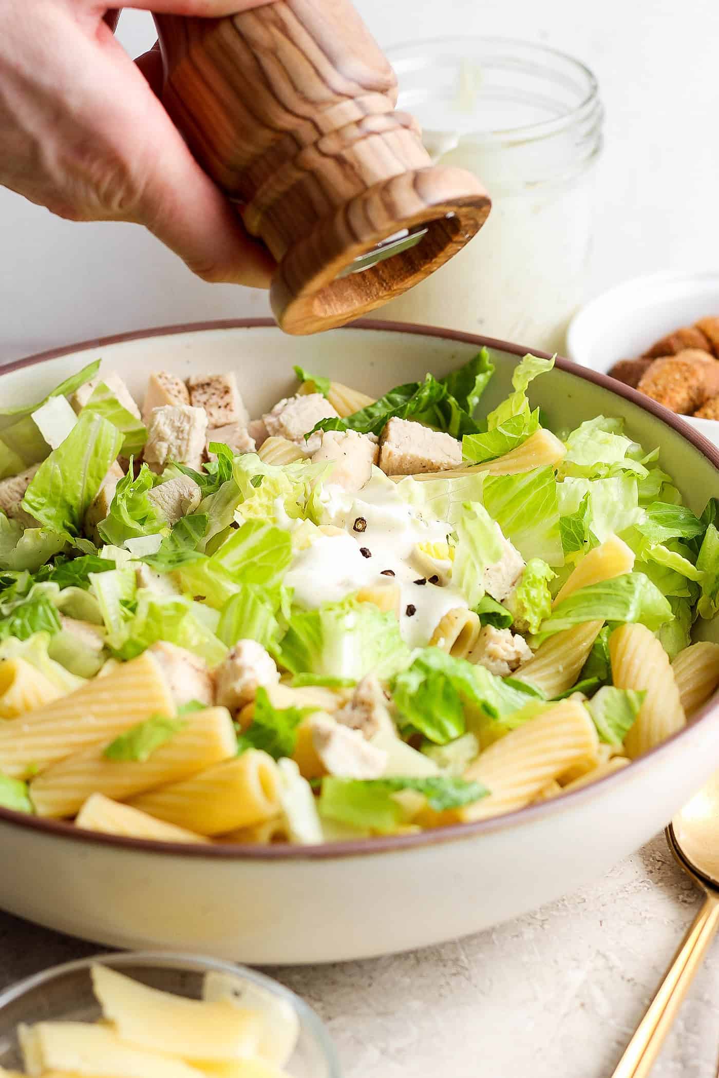 Pepper is ground into the salad.