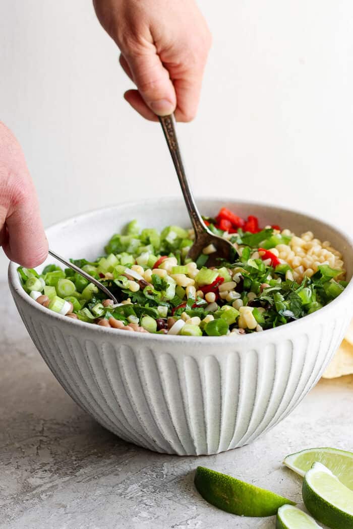 The salad is mixed together with serving spoons.