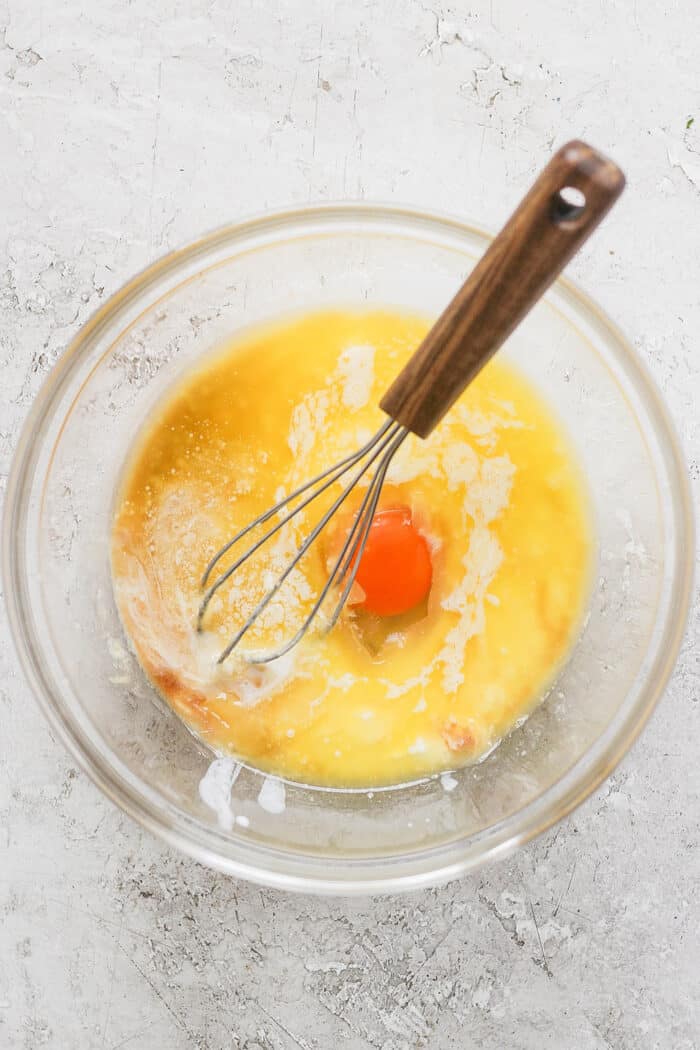 wet ingredients for muffin batter, in a clear bowl with a whisk