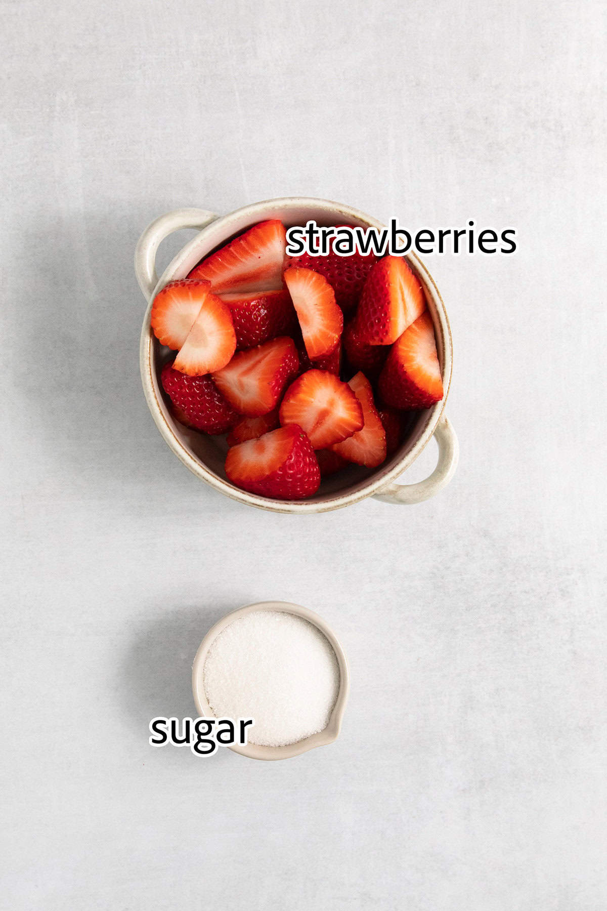 Ingredients for strawberry puree are labeled and portioned: sliced strawberries and sugar.