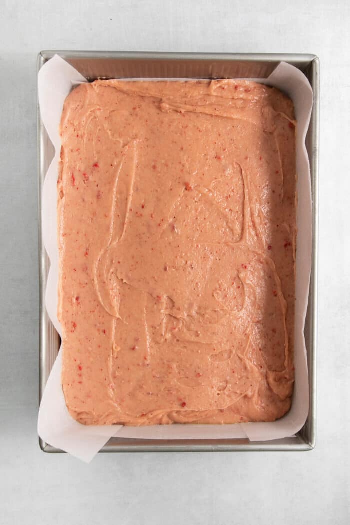The strawberry brownie batter is added to the pan.