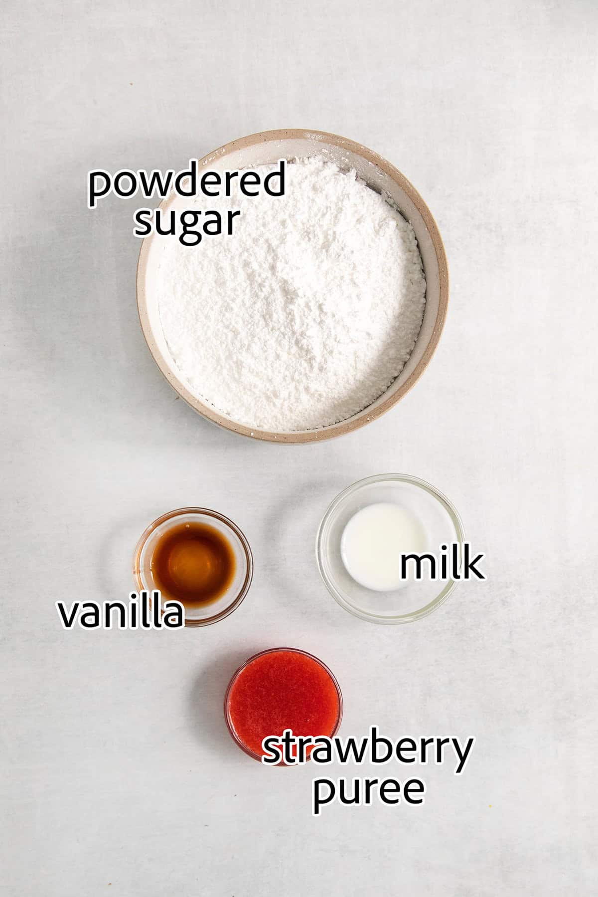 Ingredients for strawberry icing are labeled and portioned: vanilla, milk, powdered sugar, strawberry puree.