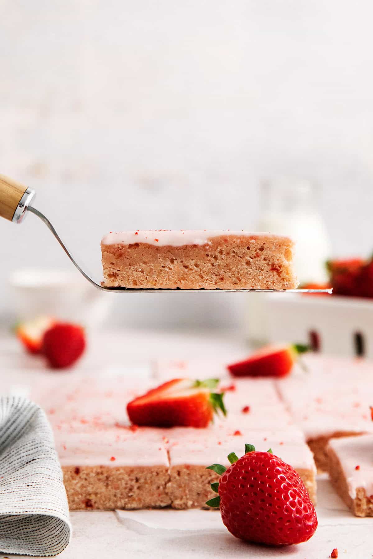 A serving utensil lifts out a strawberry bar.