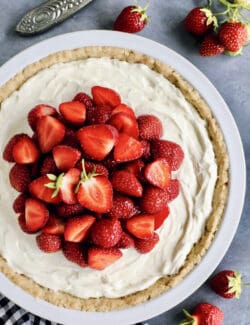 overhead photo of cream cheese pie with fresh strawberries, in a white pie plate