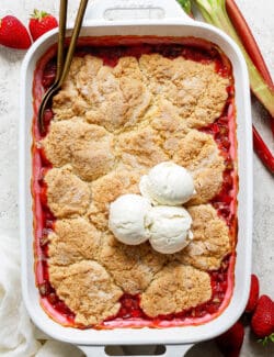 baked rhubarb strawberry cobbler in a white rectangular baking dish