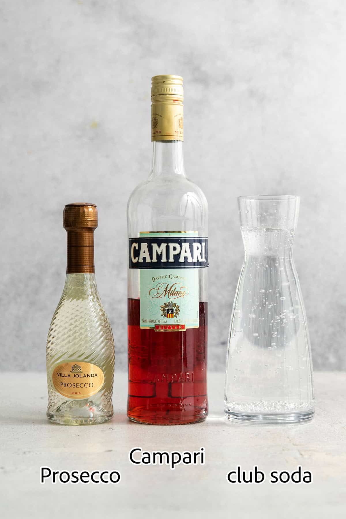 Ingredients for Campari spritz are shown: Campari, Prosecco, club soda.