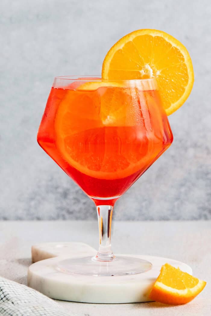 a glass of Campari spritz with an orange wheel garnish
